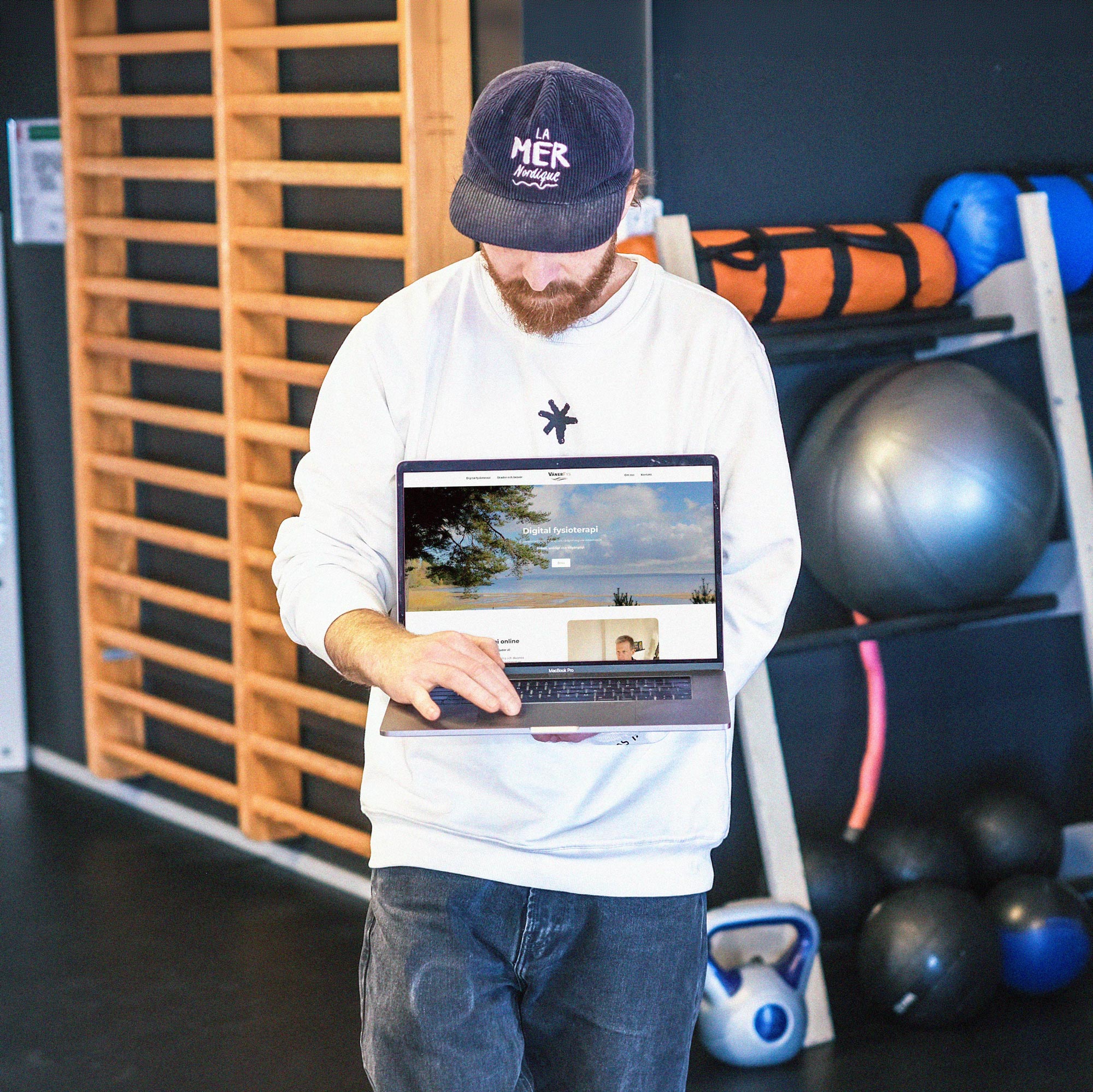 Kille står med en MacBook och visar en ny hemsida för företaget VänerFys Kille står med en MacBook och visar en ny hemsida för företaget VänerFys